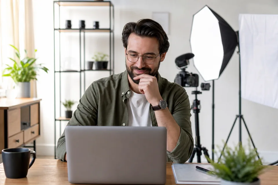 Creator reviewing his monthly earnings on a laptop in his studio